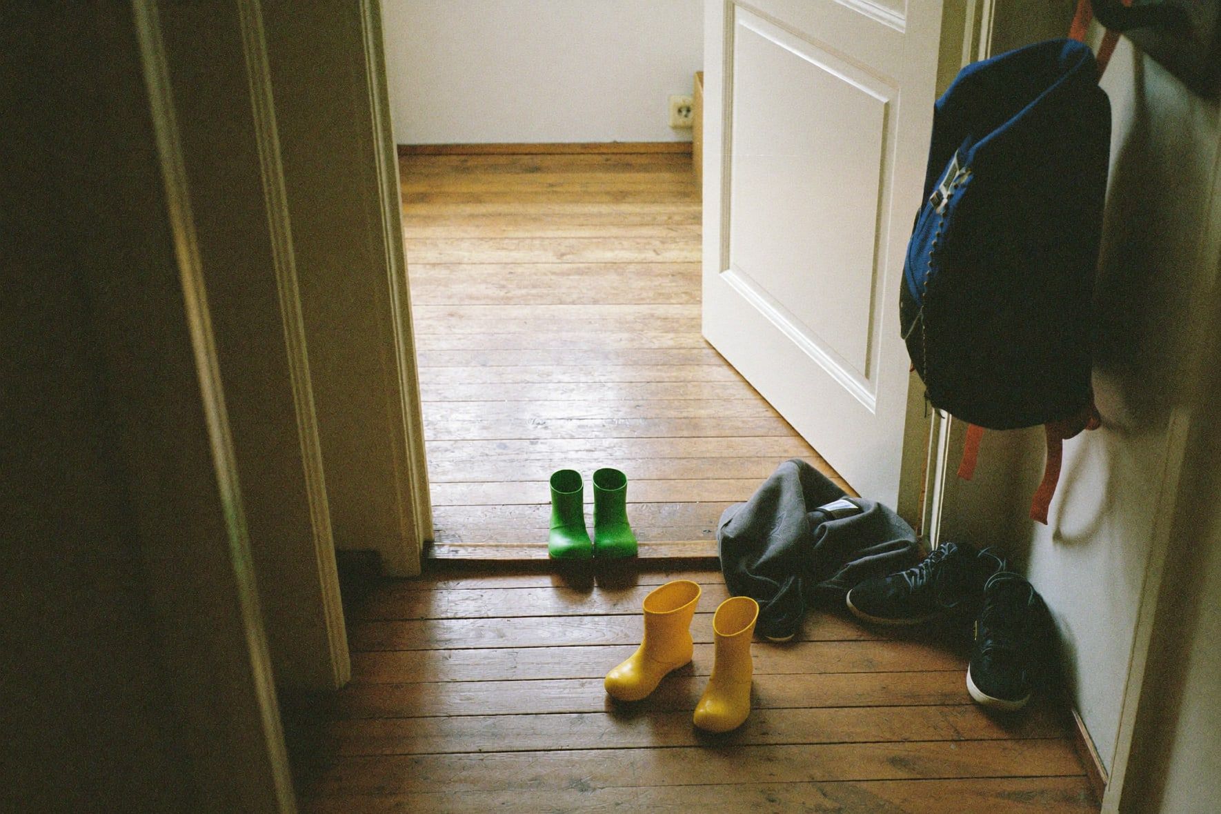 Kindergummistiefel in Gelb und Grün im Flur einer Altbauwohnung
